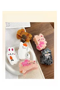 Détail de pinces à cheveux en acétate avec des motifs de lapins, chats et chiens