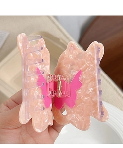 Détail de la pince à cheveux papillon en acétate marbré rose avec ressort en métal