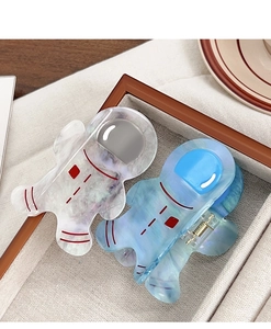 Detailed close-up of cute astronaut acetate hair claws with iridescent finish and red accents