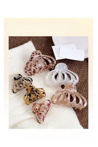 Gros plan de pinces à cheveux aux motifs léopard et marbre sur un support textile