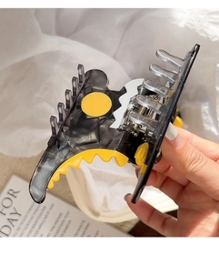 Détail de la pince à cheveux dinosaure avec de l'acétate gris transparent et jaune