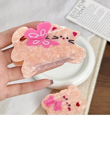 Détail de pinces à cheveux en acétate ours et chat avec texture marbrée rose et nœud