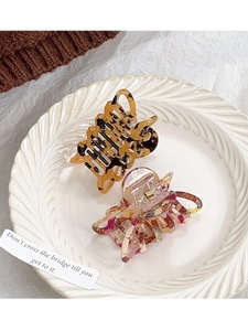 Détails des pinces à cheveux ambre et marbre rose sur une assiette décorative blanche