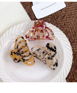 Détails de trois pinces à cheveux en acétate aux motifs floraux et écailles de tortue