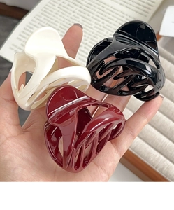 Close-up of matte resin pumpkin-shaped hair claws in white, black, and wine red colors