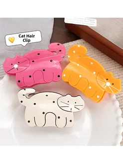 Détail de pinces à cheveux chat mignonnes à pois en rose, orange et blanc