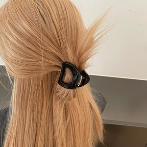 Pince à cheveux noire classique en forme de D pour femme sur de longs cheveux blonds