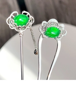 Detail of silver U-shaped hairpins with green jade-like stones and auspicious clouds