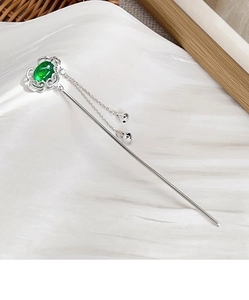 Detail of silver U-shaped hair stick with green stone, hollow cloud pattern and bell tassels
