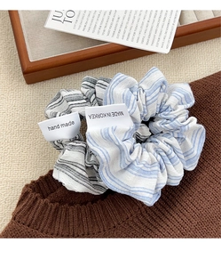 Detailed macro view of handmade striped scrunchies with labels on a knitted sweater texture