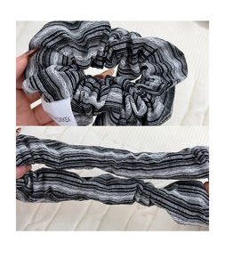 Detail of the elastic black and white striped scrunchie showing stretch and woven texture