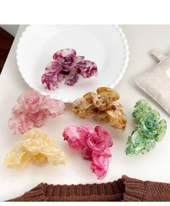 Detailaufnahme von sechs marmorierten Acetat-Rosen-Haarklammern in verschiedenen Farben