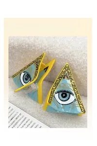 Détail de la pince à cheveux en acétate bleu et jaune avec motif œil artistique unique
