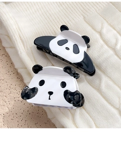 Dettaglio di due mollette per capelli a forma di panda in acetato bianco e nero