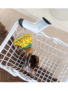 Detail view of acetate claw clips in unique sock and striped patterns in a basket