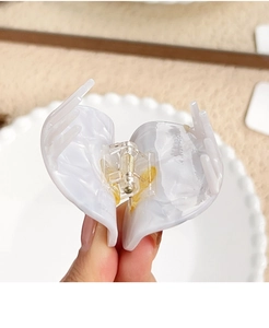 Close-up of marble pattern acetate hair claw clip showing internal metal spring detail