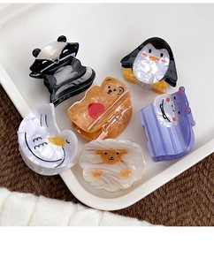 Flat lay of acetate hair clips featuring various cartoon animals on a white tray