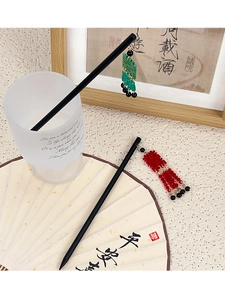 Détail de pics à cheveux chinois avec pompons et perles sur tiges en bois traditionnelles