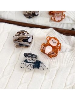 Detailed view of animal-shaped acetate hair claws including hedgehog and monkey designs