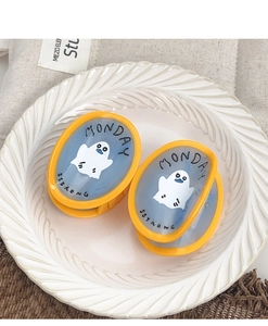 Detail of blue acetate ghost hair clips with yellow borders on a vintage plate