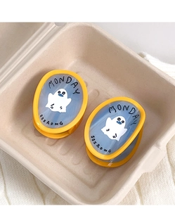 Detail of yellow acetate hair clips with blue marble texture and ghost illustrations