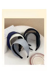 Detail of four ribbed knit wide headbands in navy, beige, grey and black colors