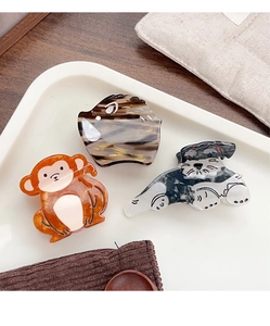 Close-up of animal-shaped acetate hair claws including schnauzer and monkey designs