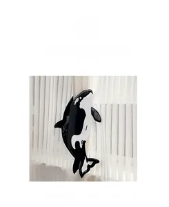 Detailed view of an orca shaped hair claw clip made of black and white glossy acetate