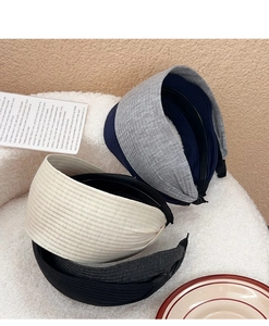 Close-up of four ribbed knit wide headbands in gray, navy blue, beige, and black colors