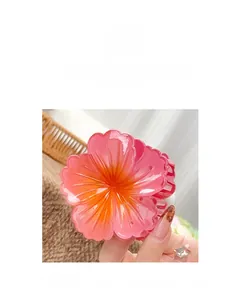 Detailed macro view of the pink and orange gradient flower hair claw made of shiny resin