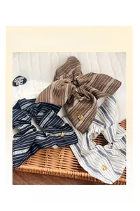 Detail of striped hair scrunchies in blue and brown with golden heart charms