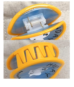 Detail view of the metal spring and blue ghost patterned hair claw clip structure