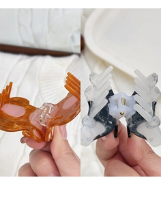 Detail view of butterfly hair claws in amber resin and black marble patterns