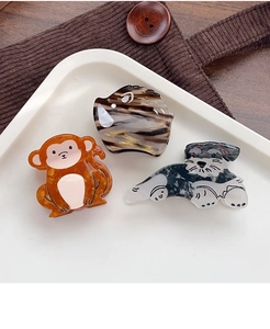 Detail of animal-shaped acetate hair clips including a monkey and a schnauzer dog