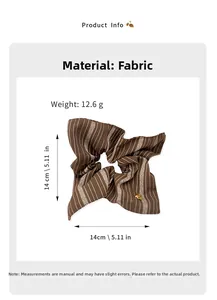 Detailed view of brown striped fabric scrunchie with a gold heart metal charm