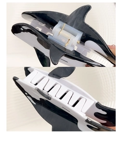 Detail view of the black and white orca hair claw clip showing hinges and internal teeth