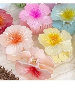 Macro shot of colorful translucent hibiscus hair claws on a soft white knit texture