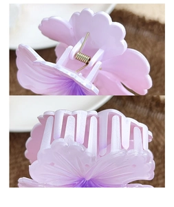 Macro detail of the purple gradient flower hair claw showing metal spring and teeth