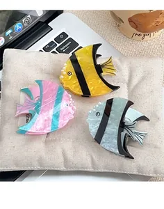 Vue détaillée de pinces à cheveux poisson tropical avec textures marbrées et perles