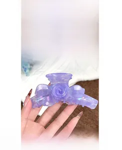 Détail de la pince à cheveux rose violette irisée au design floral en acétate