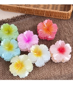 Set of six colorful summer flower hair clips on a woven texture background