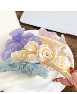 Vue détaillée des pinces à cheveux rose 3D en acétate avec finitions effet marbré chic