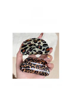 Close-up of leopard print hair claw clips in dark and light resin patterns