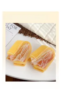 Detail of two yellow marbled claw clips with artistic white lines on a white tray