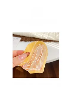 Detailed close-up of amber yellow hair claw clip with white flowing marble texture