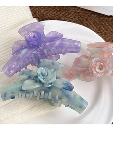 Détail de trois pinces à cheveux rose en acétate en violet, bleu-vert et rose marbré