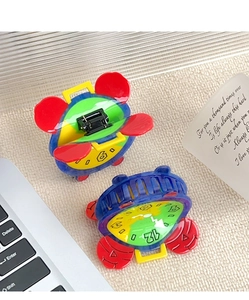 Detail of colorful acetate clock hair claw clips with mouse ears on a beige fabric