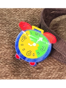 Detailed close-up of a colorful alarm clock shaped hair claw clip made of glossy acetate