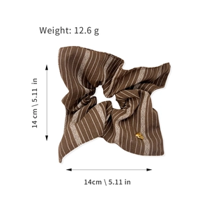 Brown striped oversized scrunchie with a gold heart charm and geometric diamond patterns