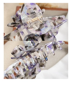 Macro details of purple marble floral hair claw with golden metal spring mechanism